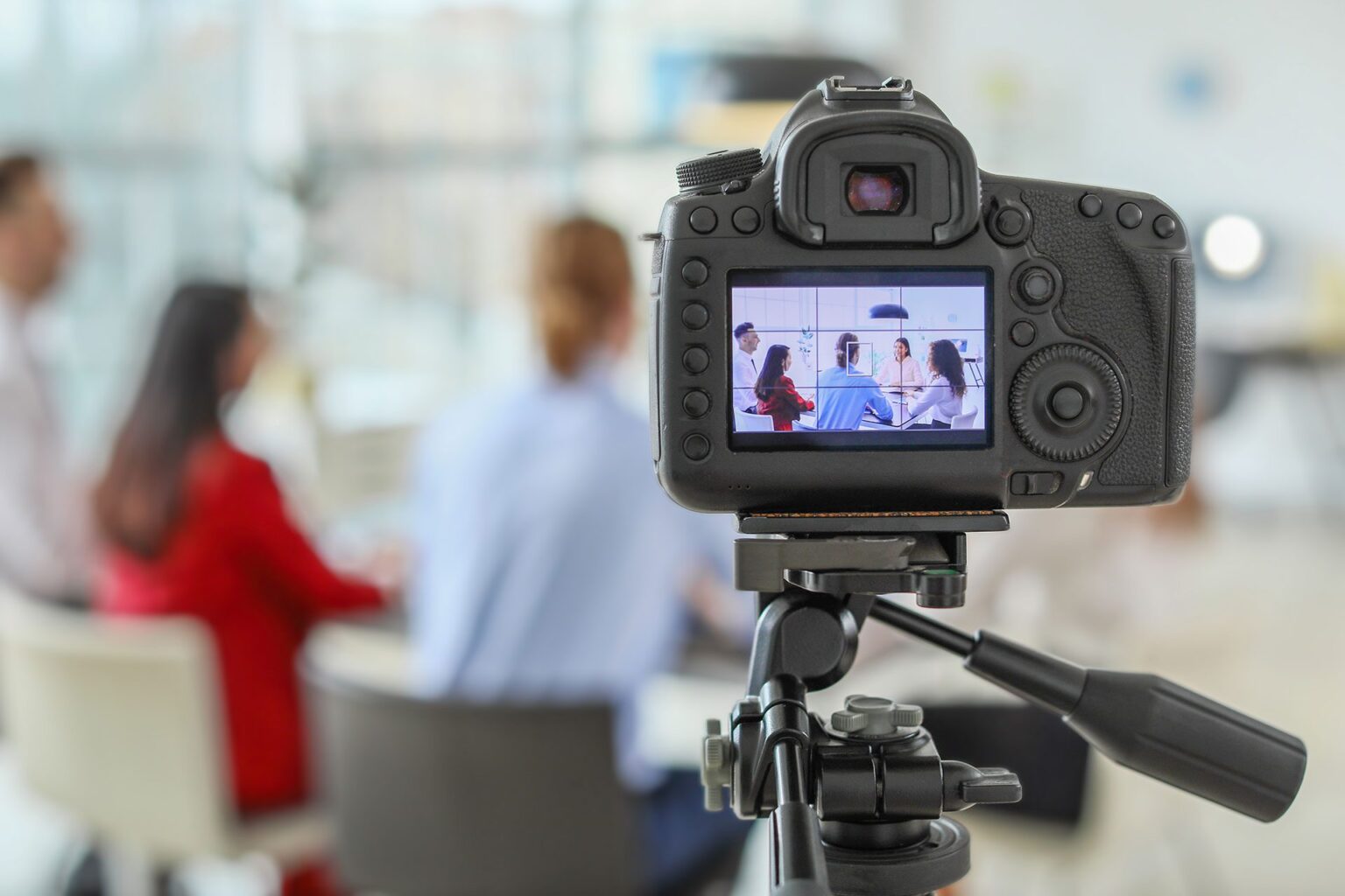 filming people working at the table, camera in foreground